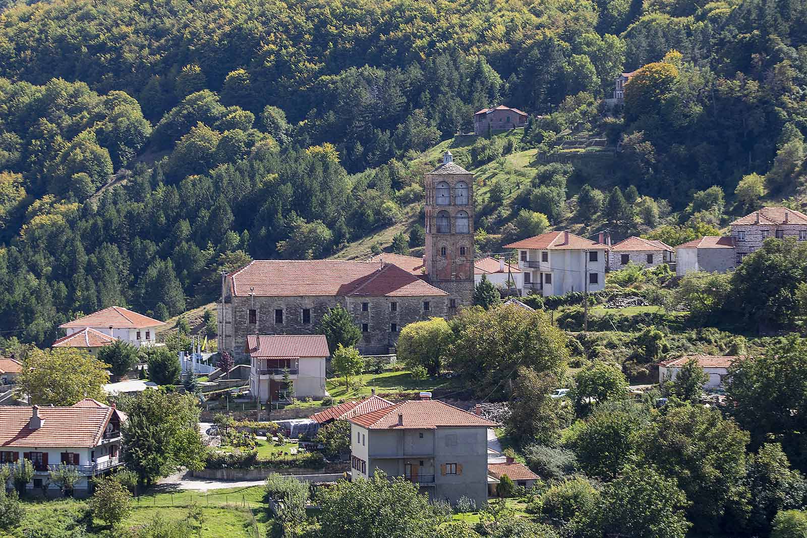 Άποψη της Κλεισούρας με παραδοσιακά κτίρια, εκκλησία και καταπράσινο ορεινό τοπίο